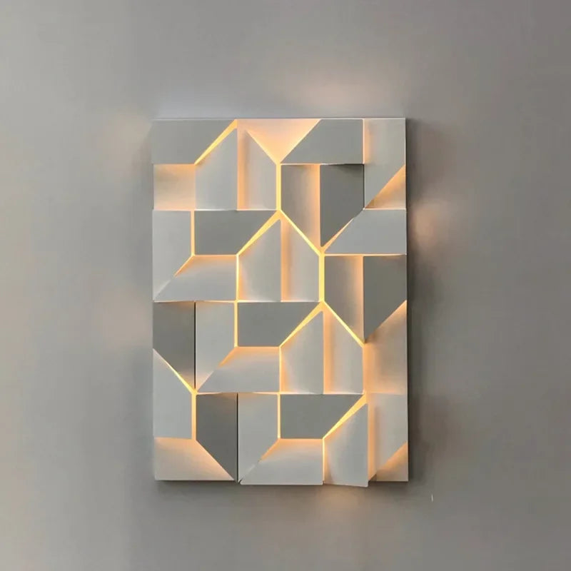 The Geometric Modern wall lights by XCEPTION present a wall-mounted fixture with a geometric design of overlapping white blocks. This creates a multidimensional effect with adjustable color temperatures. The warm light emitted from the block edges softly illuminates a plain gray wall, featuring an eye protection function for enhanced comfort.