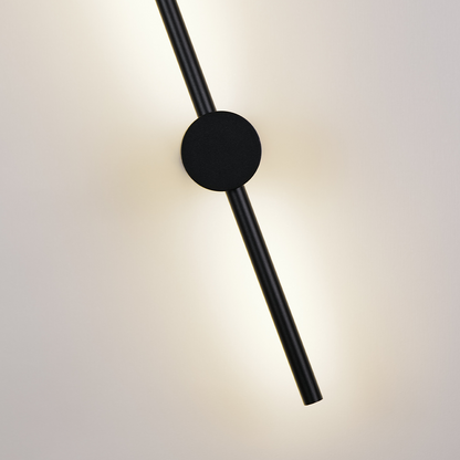 The Nordic Light Stick • 2-Pack by XCEPTION features a modern, minimalist design with a sleek black rod extending through a black circular base, beautifully mounted on a light-colored wall. The rod emits a soft glow, offering a balanced and elegant appearance.