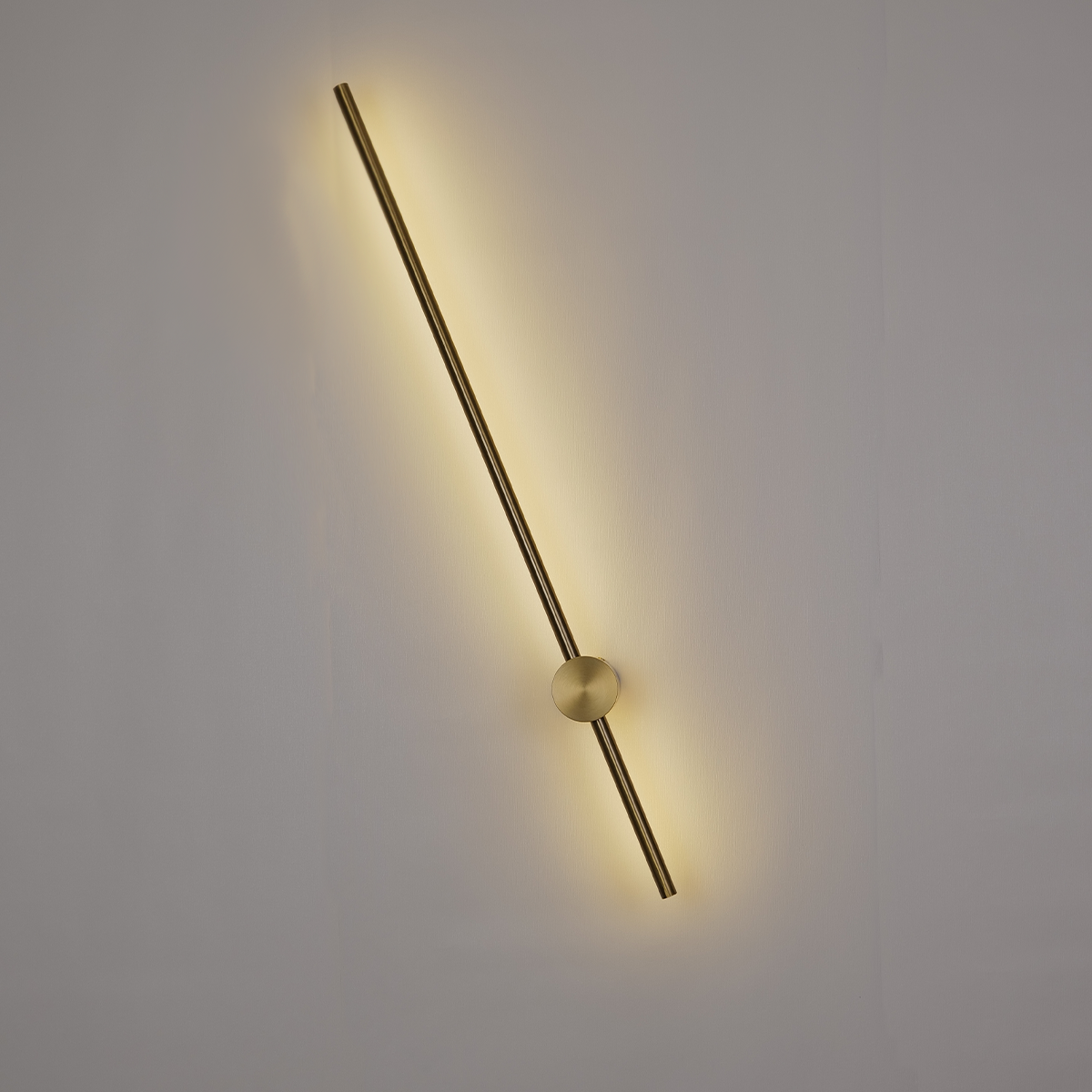 The Nordic Light Stick • 2-Pack by XCEPTION is a modern wall lamp featuring a streamlined, horizontal design with a slender metallic rod emitting a warm yellow glow from behind its central circular fixture. It is elegantly mounted on a plain, light-colored wall.