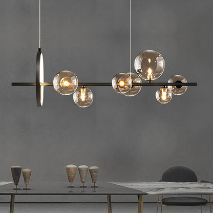 An Art Deco ceiling light from XCEPTION, featuring multiple spherical glass bulbs, is elegantly suspended above a dining table. The table is adorned with several cone-shaped decorative items and a partially visible chair, all set against a plain gray wall.