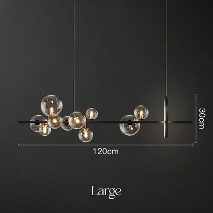 Introducing the Art Deco Ceiling Lights by XCEPTION: A contemporary chandelier showcasing an array of glass orbs with integrated lights, elegantly suspended from a sleek black linear frame. This large fixture measures 120 cm in length and 30 cm in height, perfectly contrasted against a dark backdrop.
