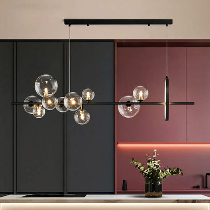 A modern kitchen interior featuring a sleek black and red color scheme showcases the XCEPTION Art Deco Ceiling Lights, with glowing bulbs encased in transparent glass orbs that hover elegantly above a white countertop. A small plant in a vase introduces a touch of greenery into the space.