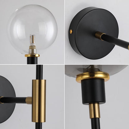Here are close-up images of the Scandi Wall Lights by XCEPTION, showcasing a modern design with a clear glass globe shade. These fixtures embody Scandinavian aesthetics, highlighted by black and gold accents, a cylindrical support, and an energy-efficient LED bulb. The round base complements its sleek and contemporary style.